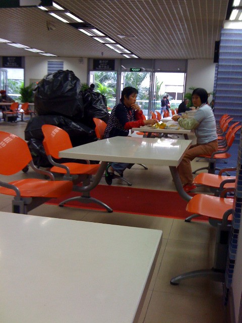 Cina Canton Mac Donald stimolannte mangiare da davanti a pile di sacchi neri dell'immondizia